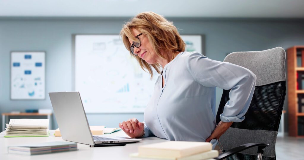 Woman In Office Struggles With Lower Back Pain